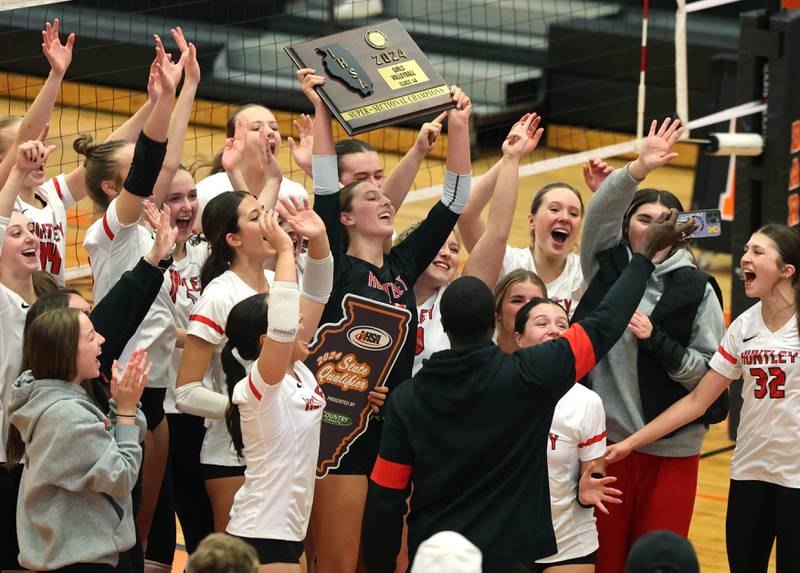 Huntley players hoist the championship plaque Monday, Nov. 11, 2024, after their Class 4A supersectional win over Fremd at DeKalb High School.