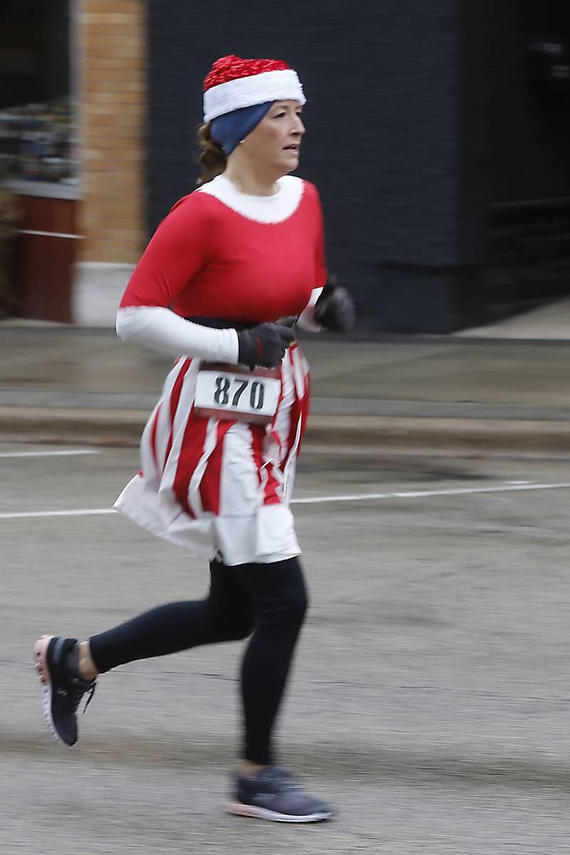 Amy Liggett runs to the finish line during the McHenry County Santa Run For Kids on Sunday morning, Dec. 3, 2023, in Downtown Crystal Lake. The annual event raises money for agencies in our county who work with children in need.