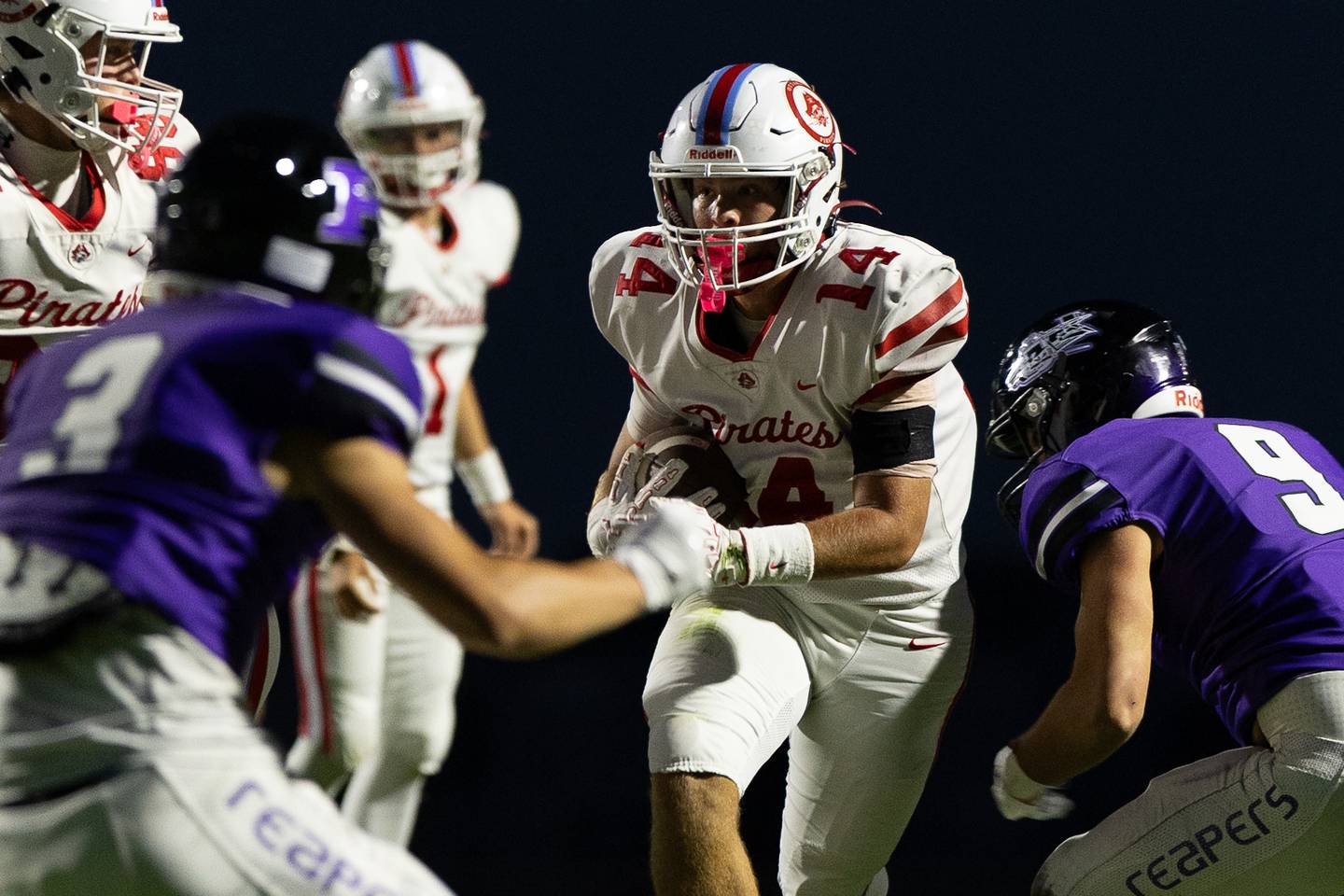 Ottawa running back Archer Cechowicz (14) looks to split two Plano defenders during Friday's game in Plano.