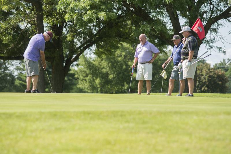 Ed Dunn (left), Brian Weidman, David Kemp and Greg Ohlendorf work the green Tuesday in Amboy.