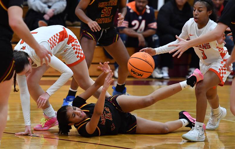 Montini’s Nathalia Richardson passes the ball from the floor as Minooka’s Kendall Thomas (right) moves to deflect the ball during a Montini Christmas Tournament game on December 22, 2025 at Montini Catholic High School in Lombard.