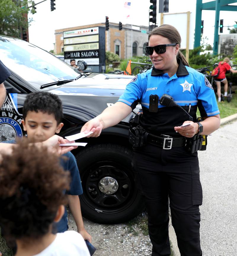 Batavia Police Officer Jamie Goschey hands out coupons for free ice cream scoops outside the Batavia Creamery on Thursday, June 6, 2024.