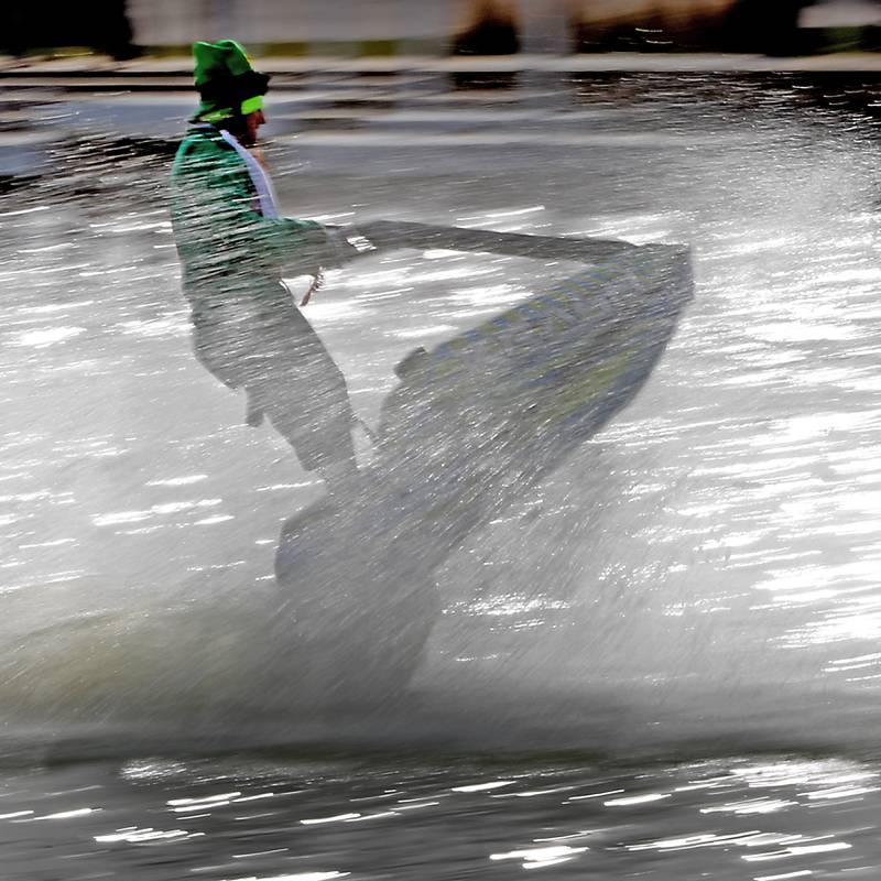 A jet skier dressed as a leprechaun stirs dye into the Fox River during the ShamROCKS the Fox Festival in McHenry on Saturday, March 16, 2024.