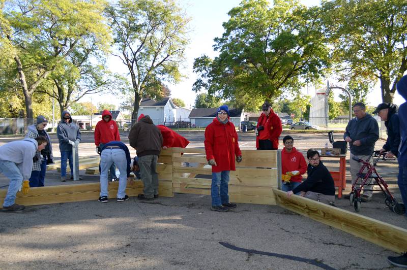 Gab Buelvas, 17, of Dixon, (center, blue hat), grins as he leads a group of about 15 people in building a gaga ball pit for Vaile Park on Saturday, Oct. 7, 2023. The gaga ball pit was Buelvas' Eagle Scout project.