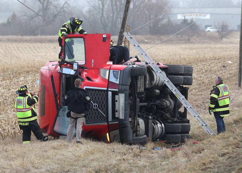 Cortland firefighters and police work to secure the cab of a semitrailer that rolled into the ditch Wednesday, Jan. 7, 2026, on the north side of Lincoln Highway in Cortland.