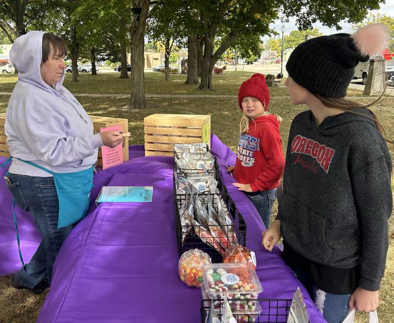 Jane Koeller, of Gramma's Sweet Treats of Forreston, (left) served up freeze-dried treats from her booth at the Mt. Morris Fall Family Festival on Sunday, Oct. 13, 2024. The event was held in conjunction with the Evangelical Free Church of Mt. Morris Trunk or Treat in the village's square.