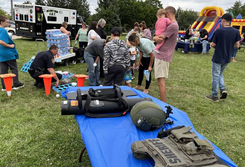 Byron Police Chief Jeremy Boehle, left, works one of the booths for kids during National Night Out on Tuesday, Aug. 6, 2024 in Byron. The event was hosted by the Ogle County Sheriff's Department, Byron Police Department and Byron Fire Department.