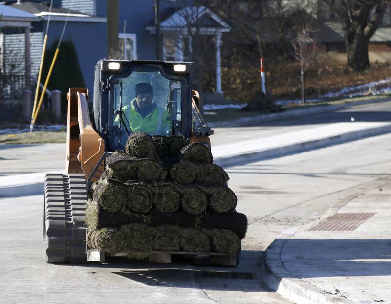 Sod is moved as workers put the finishing touches on the Woodstock roundabout at intersection of Lake Avenue and South and Madison streets on Tuesday Nov. 22, 2022. Construction on the roundabout near Woodstock's downtown is expected to wrap up this week, opening traffic and marking the end of several months of construction. The roundabout has been in the works for several years and was built out this year.