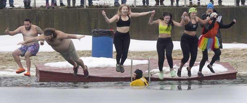 Team Francisco makes a coordinated dive Saturday, Jan. 27, 2024, into he icy waters at the swimming pond at Skydive Chicago in Ottawa during the annual Penguin Plunge.