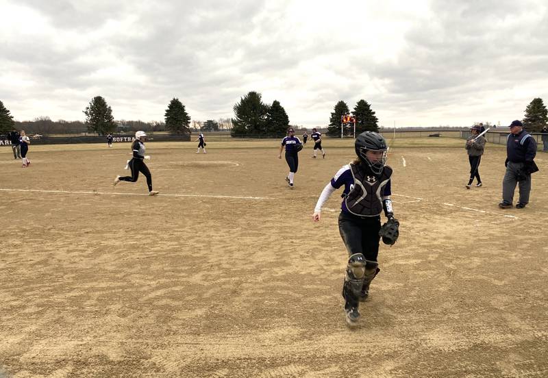 Peoria Christian catcher Claire Chism chases a wild pitch to the backstop as Woodland/Flanagan-Cornell baserunner Ella Sibert races home from third base during the third inning of WFC's 10-5 win at Woodland School on Tuesday, March 22, 2022.
