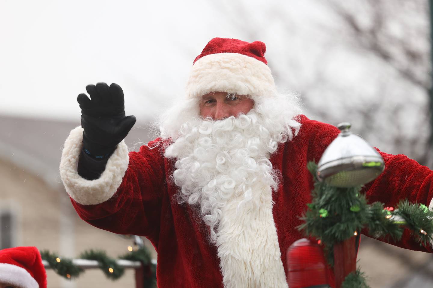 Santa waves to a family as the Joliet police escorts him through Joliet as he heads to the North Pole to get ready for Christmas Eve on Saturday, Dec.16th in Joliet.
