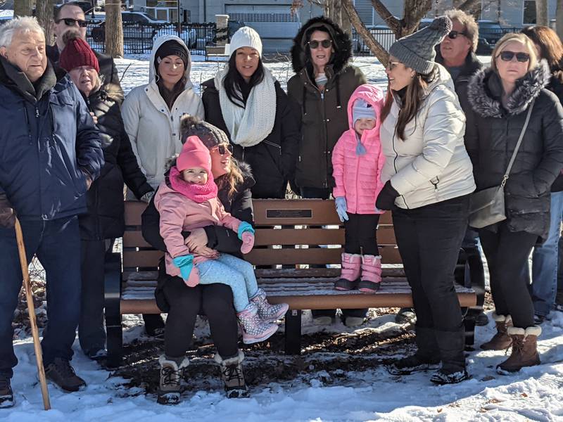Friends and family of Oswego resident Amanda Zentmyer Olson gather following a ceremony on Nov. 28 dedicating a memorial bench at Hudson Crossing Park in downtown Oswego in her name.