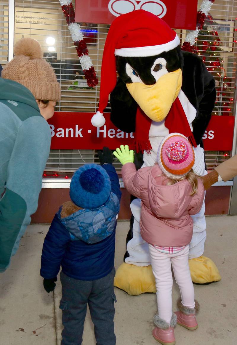 Bernie the Penguin gets high fives from children at the 2023 Elburn Christmas Stroll on Saturday, Dec. 2, 2023.