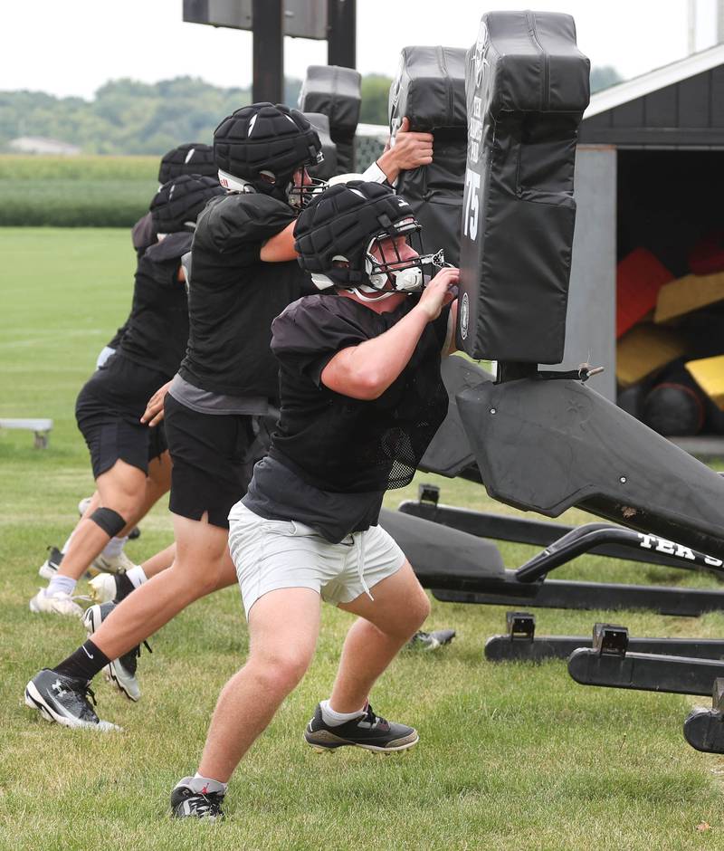 Kaneland defensive linemen hit the blocking sled Monday, Aug. 18, 2025, during practice at the school in Maple Park.