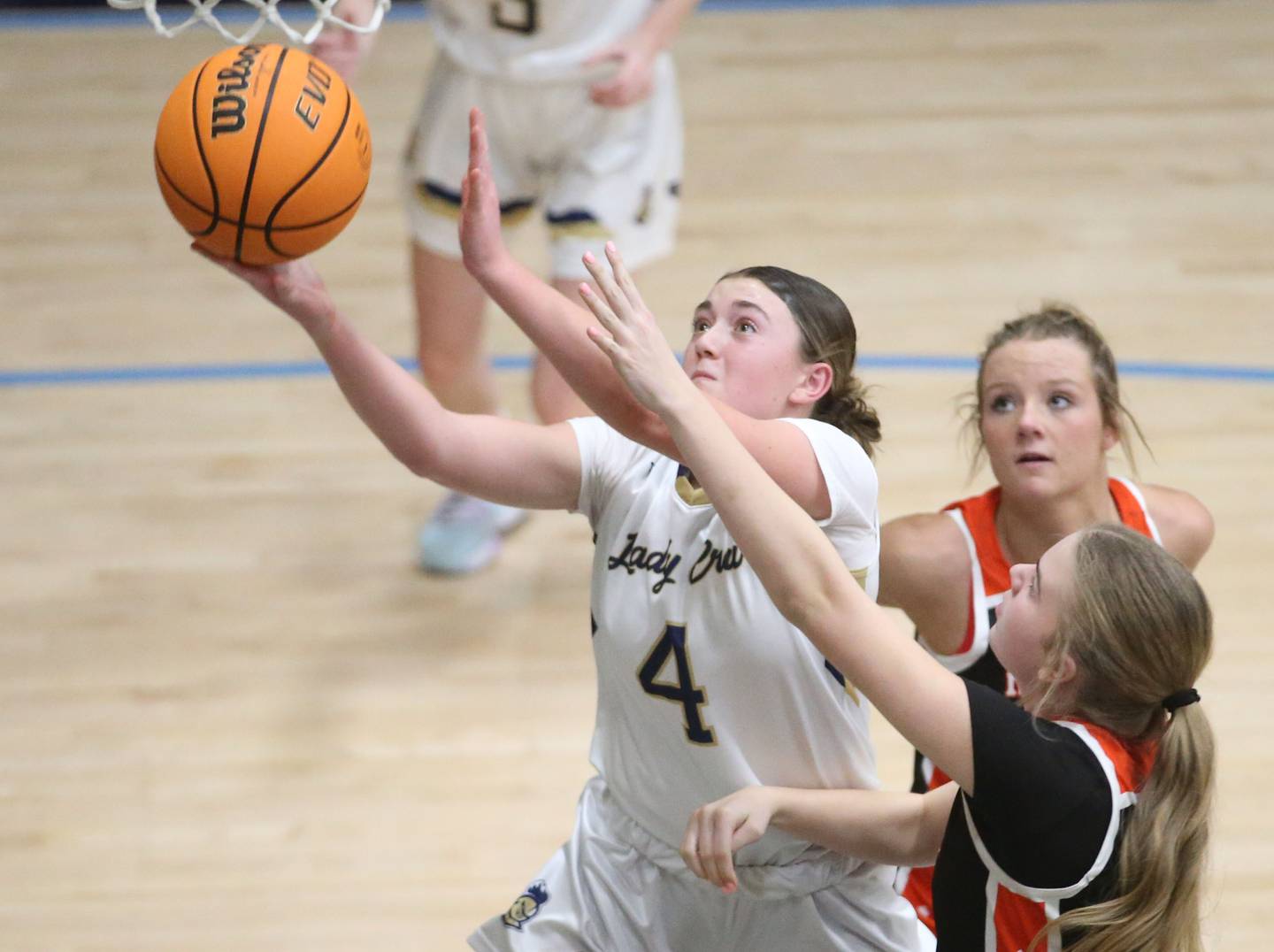 Marquette's Hunter Hopkins drives to the hoop past Roanoke-Benson's Kamryn Kennell and Bri Harms on Thursday, Feb. 6, 2025 in Bader Gym at Marquette High School.