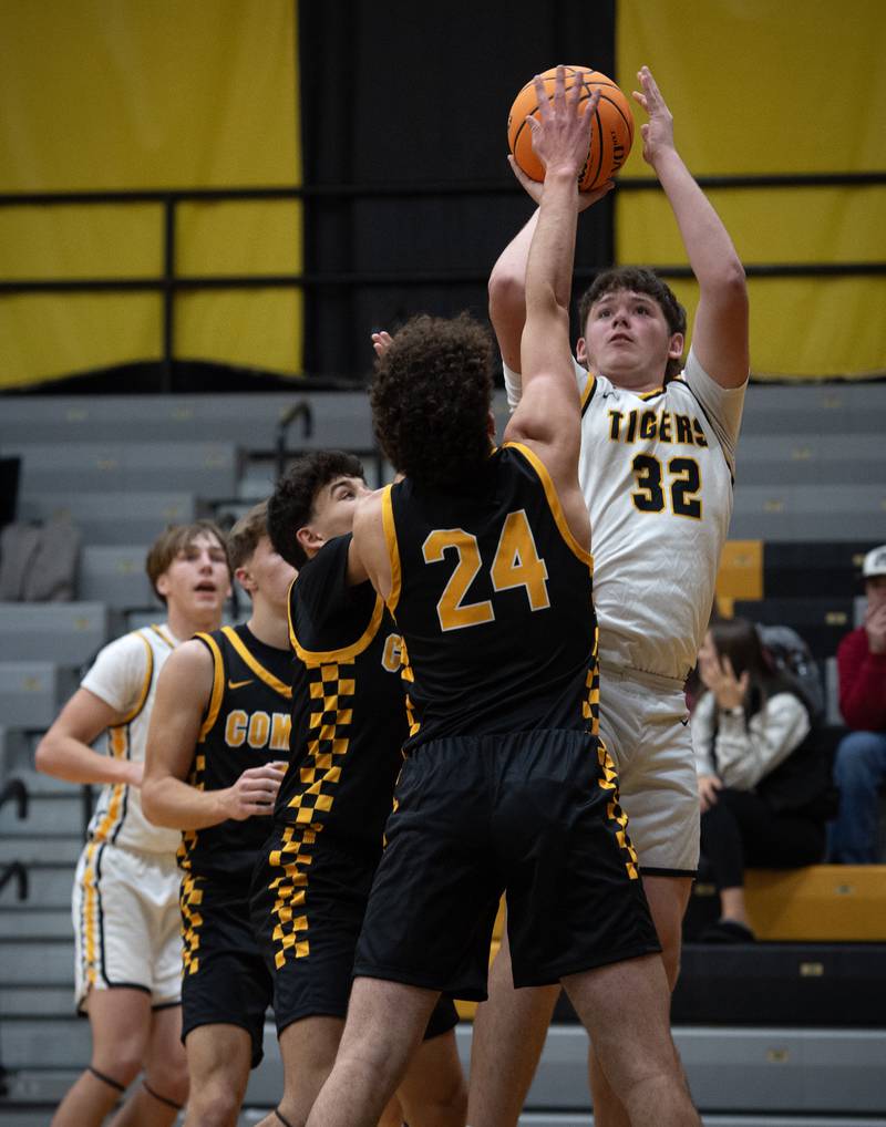 Herscher's Mason Zirkle elevates for a shot as Reed-Custer's Colton Waldvogel and Chase Isaac, left, defend in a game on Wednesday, November 26, 2025.