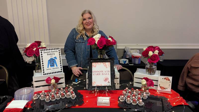 Christine Whitmer of Manhattan, owner of Sweet Swirls Bakery, poses for a photo behind her table  at the Shorewood HUGS annual chocolate ball on Saturday, February 1, 2025, in joliet.
