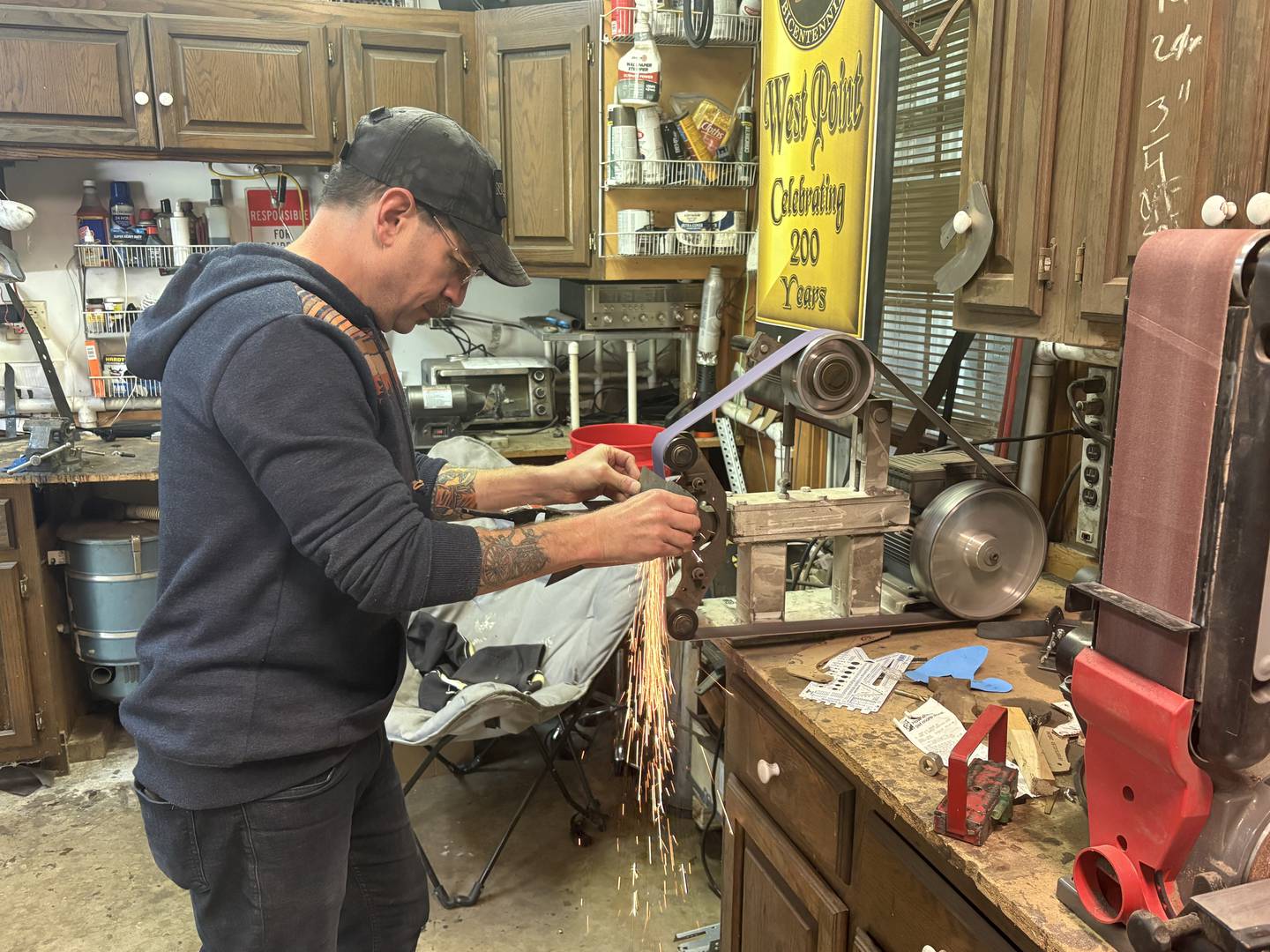 Army veteran Doug Katz shapes a piece of metal into a knife in his garage workshop in Trout Valley.