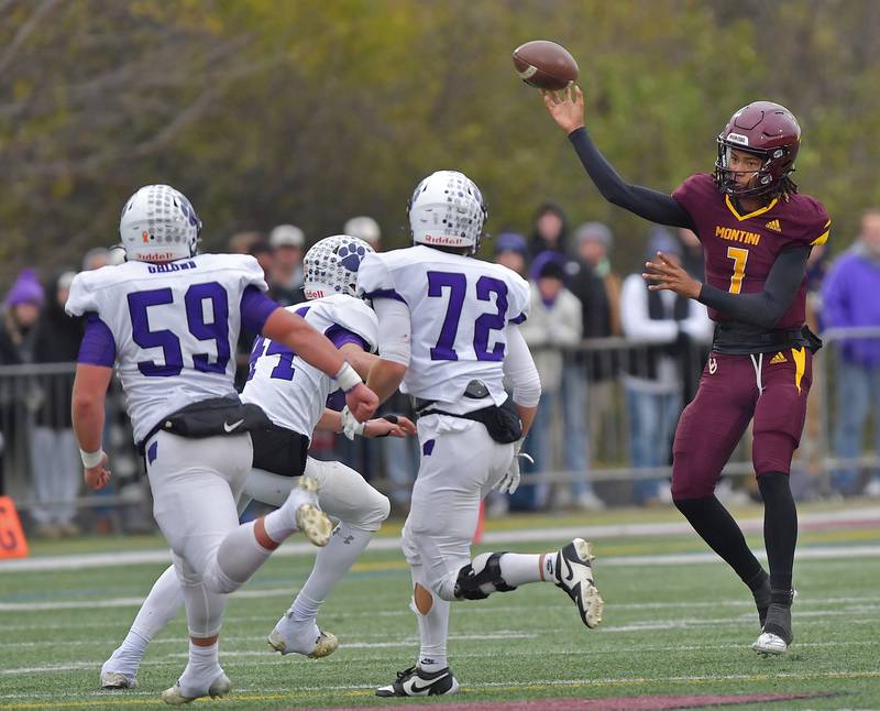 Montini quarterback Israel Abrams passes over three Wilmington defenders during a Class 3A semifinal game on November 23, 2024 at Montini Catholic High School in Lombard.