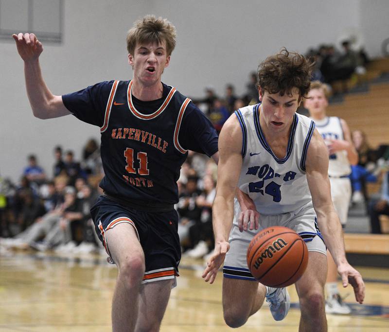 Naperville North’s Jack Kallstrand tries to slap away a pass to St. Charles North’s Charles Farrell in a boys basketball game in St. Charles on Wednesday, January 18, 2023.