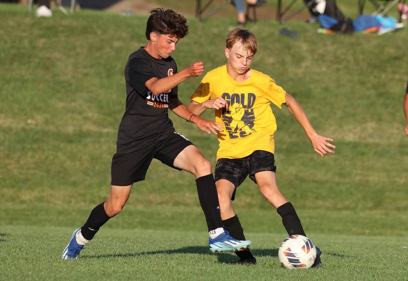 DeKalb and Sycamore players fight for possession Wednesday, July 17, 2024, during their scrimmage game at Sycamore High School.