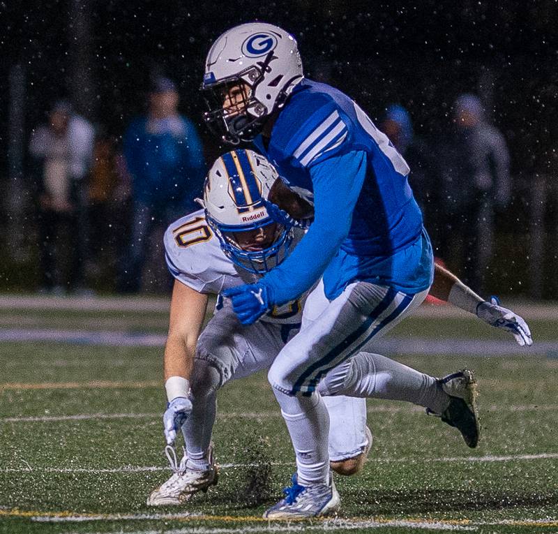 Geneva’s Dylan Reyes (80) is hit after the catch by Wheaton North’s Tyler O'connor (10) during a football game at Geneva High School on Friday, Oct 14, 2022.