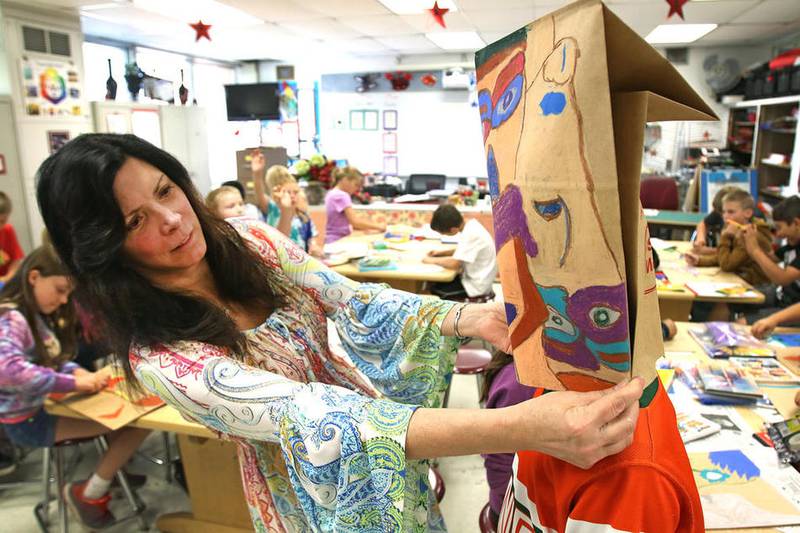 McHenry Elementary School District 15 art teacher Tina Wagner helps fifth-grader Cooper Cohn adjust his Picasso-style mask art project during class Sept. 22 at Valley View Elementary School. Wagner has taught with McHenry since 1998 and is behind three public art projects in the art, including the Art Garden at Valley View Elementary School. She was chosen as Artist of the Month by the "I Like Illinois" website, a project thought up by Senate President John Cullerton as a way to promote the state.