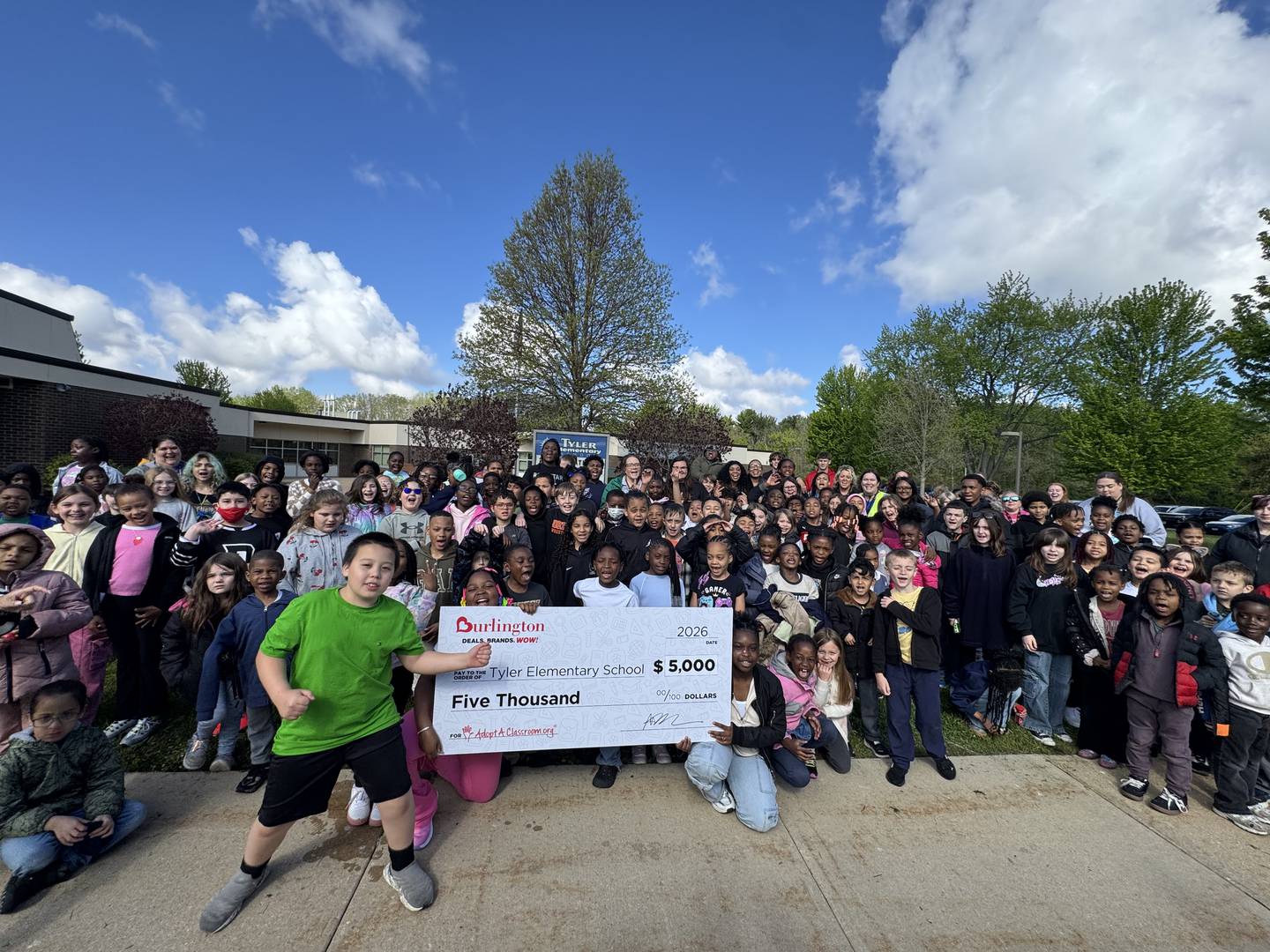 Tyler Elementary School students pose with a check denoting a $5,000 donation through Adopt A Classroom to the school from Burlington Stores. The donation was given as a surprise during the store's grand opening on Friday, May 1, 2026, in DeKalb.