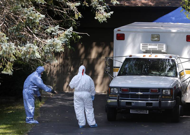 Investigators walk around the side of a home in 5800 block of Wild Plum Road in unincorporated Crystal Lake on Thursday, Aug. 10, 2023, as the McHenry County Sheriff's office continued to investigate the scene where four family members, including three females and a male “aggressor,” were killed Wednesday.