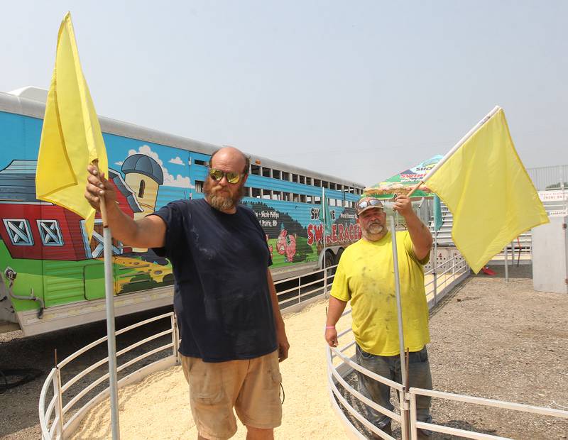 Ryan Howell gets some help from Michael Evans, both of East Prairie, Missouri and with the Show-Me Swine Racers, putting up flags around the racetrack for their pigs before the start of the Lake County Fair on Tuesday, July 25th at the Lake County Fairgrounds in Grayslake. The fair runs from July 26th-30th.
Image by Candace H. Johnson for Shaw Local News Network