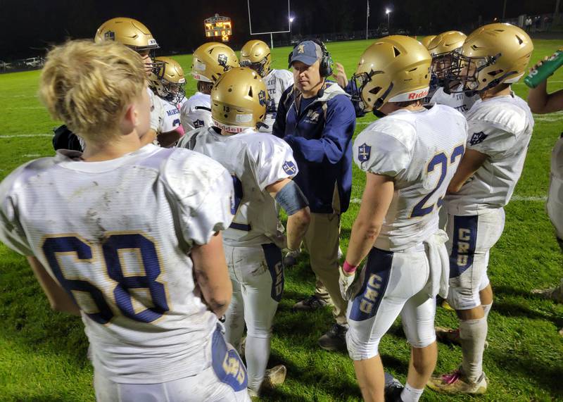 Marquette defensive coordinator Ken Carlson gives his team instruction during a timeout in the Crusaders' Chicagoland Prairie Conference game at Dwight on Friday night.