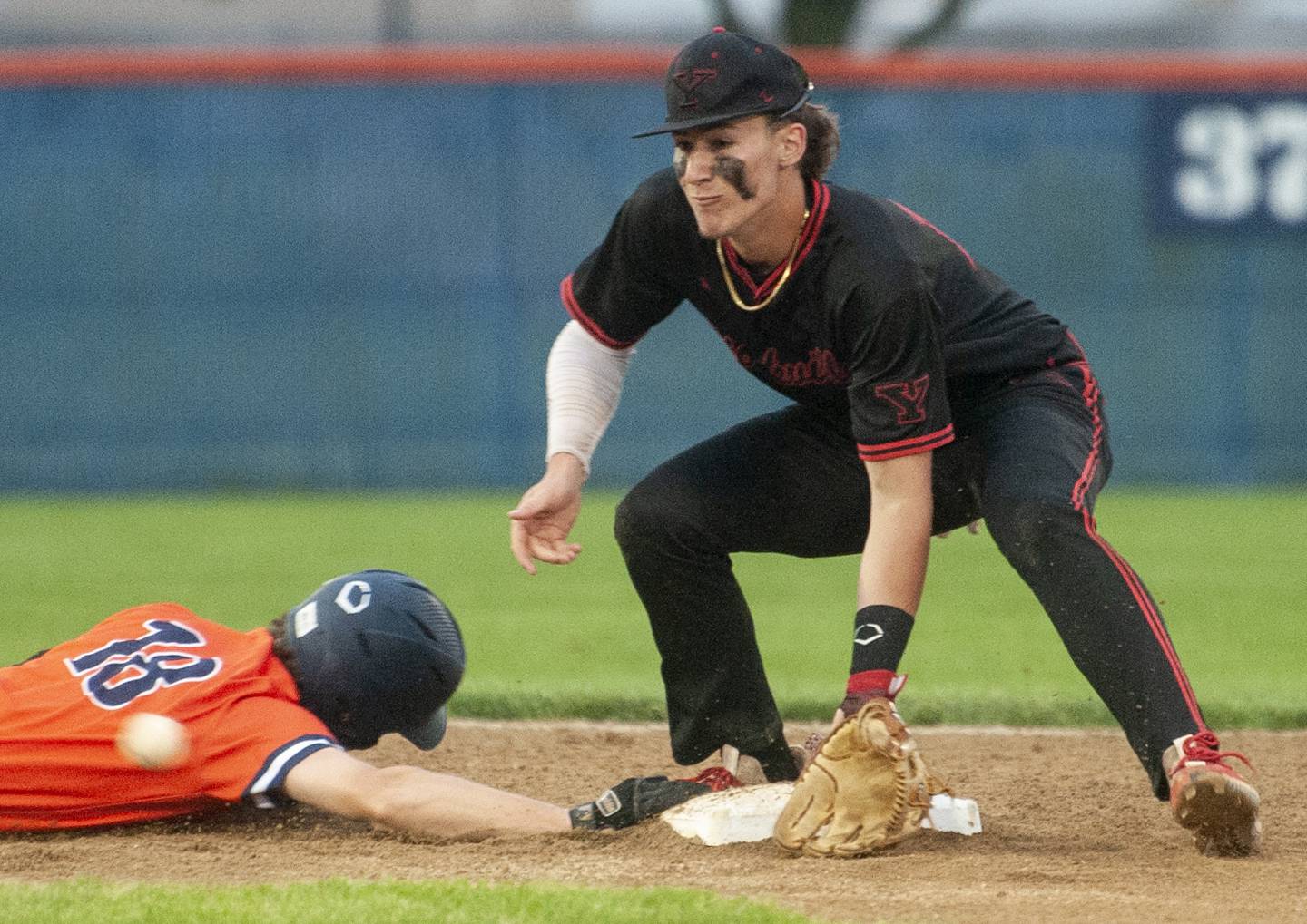 Oswego base runner Troy Vosburgh (18) slides safely back to second as Yorkville shortstop Owen Ross fields a late pickoff throw during a varsity boys baseball game on Wednesday, May 18, 2022 at Oswego High School.