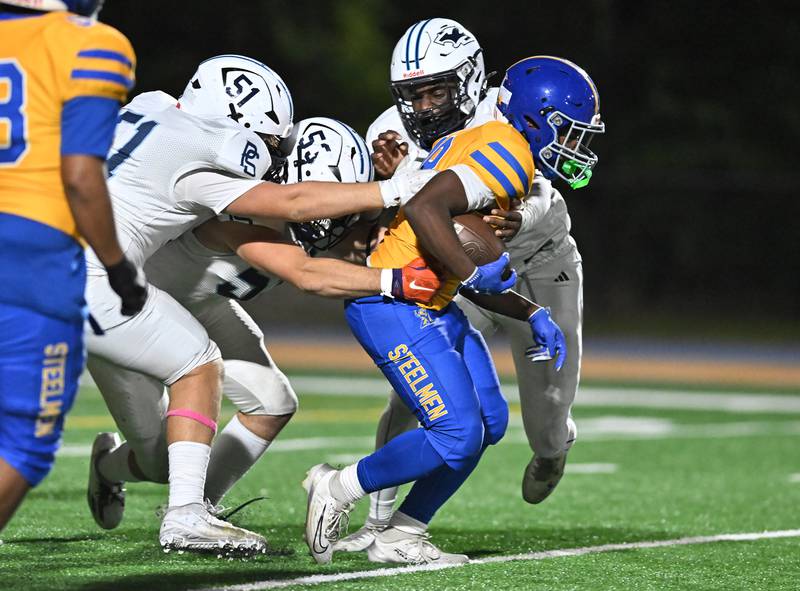 Joliet Central's Tristen Sellers (18) tries to break a tackle during the conference game against Plainfield South on Friday, OCT. 17, 2025, at Joliet.