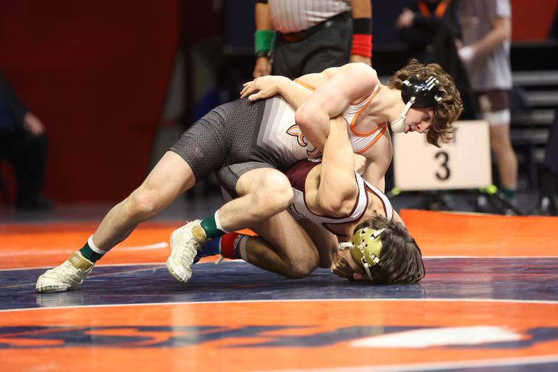 St. Charles’ Ben Davino works over Loyola’s Massey Odiotti in the Class 3A 120lb. championship match at State Farm Center in Champaign. Saturday, Feb. 19, 2022, in Champaign.