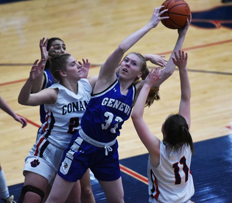 Geneva's Lauren Slagle (33) pulls down a rebound by Conant's Mikayla Nowicki and Lauren Fricke (11) during Friday’s IHSA Class 4A girls basketball regional championship in Hoffman Estates.