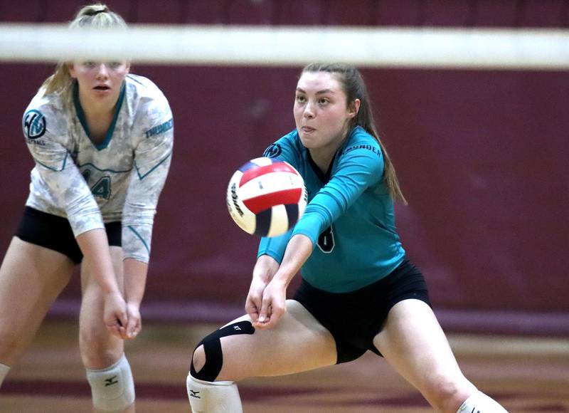 Woodstock North’s Katie Wickersheim, right, passes the ball as teammate Devynn Schulze, left, keeps an eye on the action at Marengo High School Thursday evening.