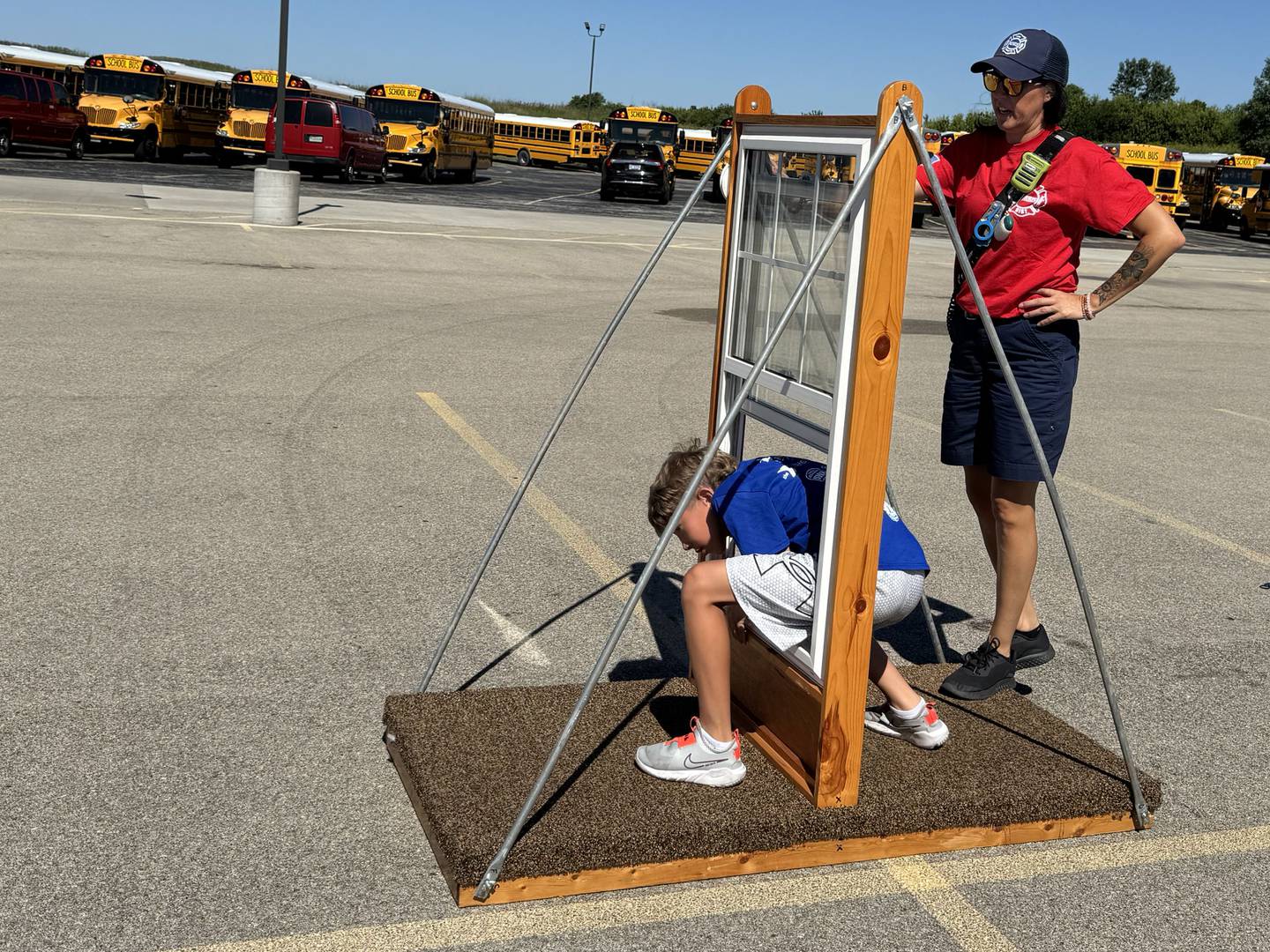 9-year-old Zac climbs through the window in the Morris Fire Department's escape-the-house obstacle course.