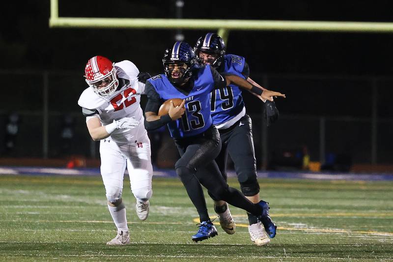 Lincoln-Way East’s Jonas Williams scrambles against Naperville Central on Friday, Oct. 25, 2024 in Frankfort.