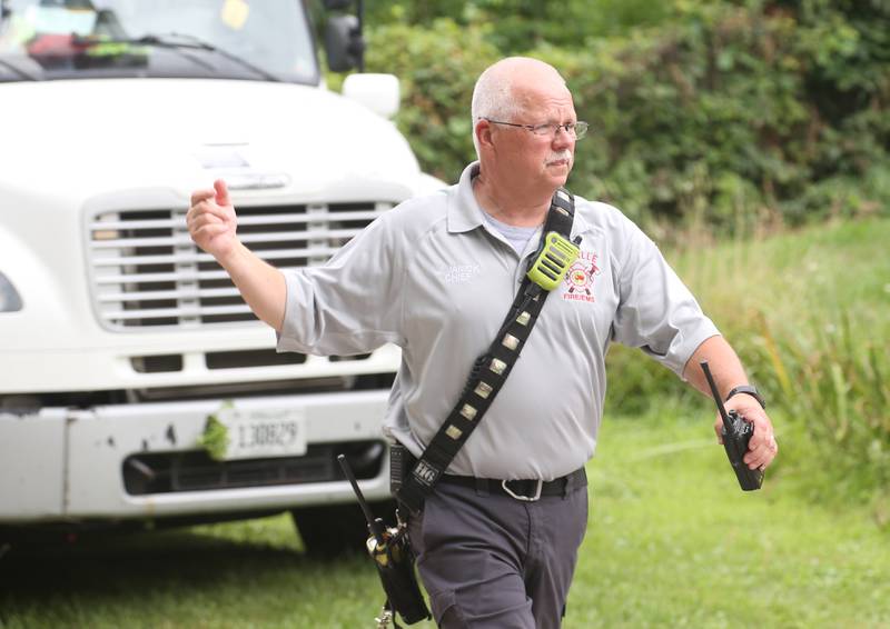La Salle Fire Chief Jerry Janick motions for help during a fully-engulfed structure fire in the 500 block of North 2782nd Road on Monday, July 21, 2025 in La Salle. FIre departments from Utica, Wallace, Naplate, Spring Valley, Mendota, Troy Grove, La Salle, Peru, Oglesby and Tonica responded to the scene. Fire crews were dispatched at 9:45 a.m. La Salle Police and La Salle County Sheriff were also on the scene.
