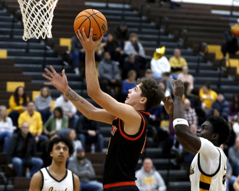 McHenry's Caleb Jett drives to the basket in front of Jacobs' Samson Averehi during a Fox Valley Conference basketball game on Friday, Jan. 24, 2025, at Jacobs' High School.