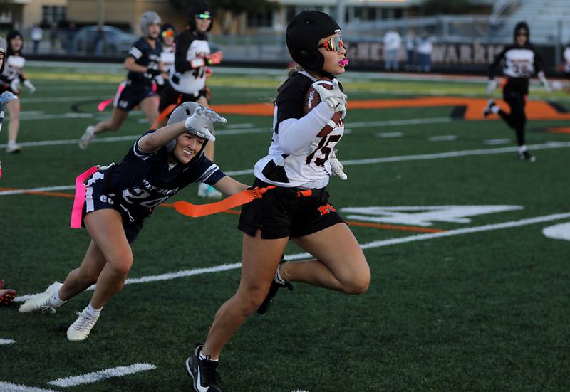 McHenry's Addison Hoffman runs away from Cary-Grove's Aria Stanton during the IHSA McHenry Regional girls flag football championship game on Wednesday, Oct. 8, 2025, at McCracken Field in McHenry.