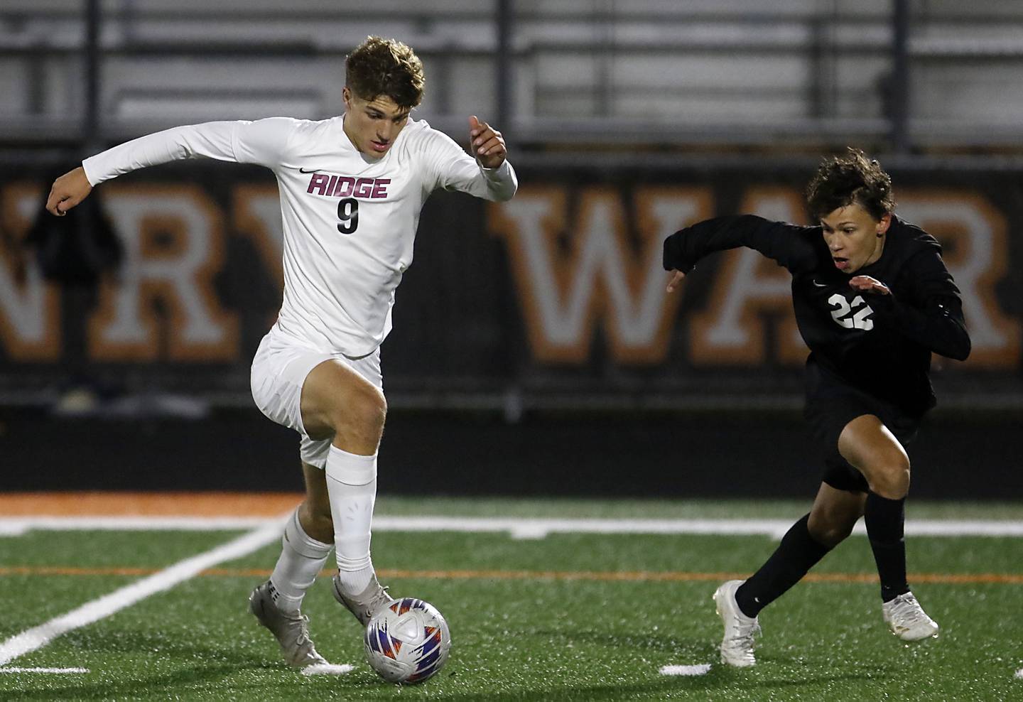 Prairie Ridge's Henry Knoll pushes the. Ball up the field as he is defended by McHenry's Evan Camargo during a Fox Valley Conference soccer match on Tuesday, Oct. 15, 2024, at McCraken Field in McHenry.