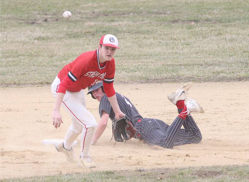 Hall's Hunter Edgecomb slides safely into second base as Streator's Blaize Bressner bobbles a ground ball on Tuesday, March 18, 2025 in Foley Field at Kirby Park in Spring Valley.