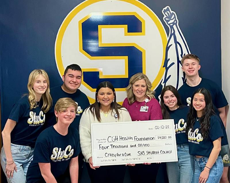 Executive Director Amanda Blaine and Sierra Bushman of the CGH Health Foundation receive a check from members of Sterling High School's Student Council.