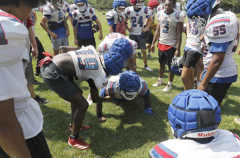 Dundee-Crown's Xavier Ingram is encouraged by his teammates as he does pushups during football practice on Tuesday, July 29, 2025, at Dundee-Crown High School in Carpentersville.