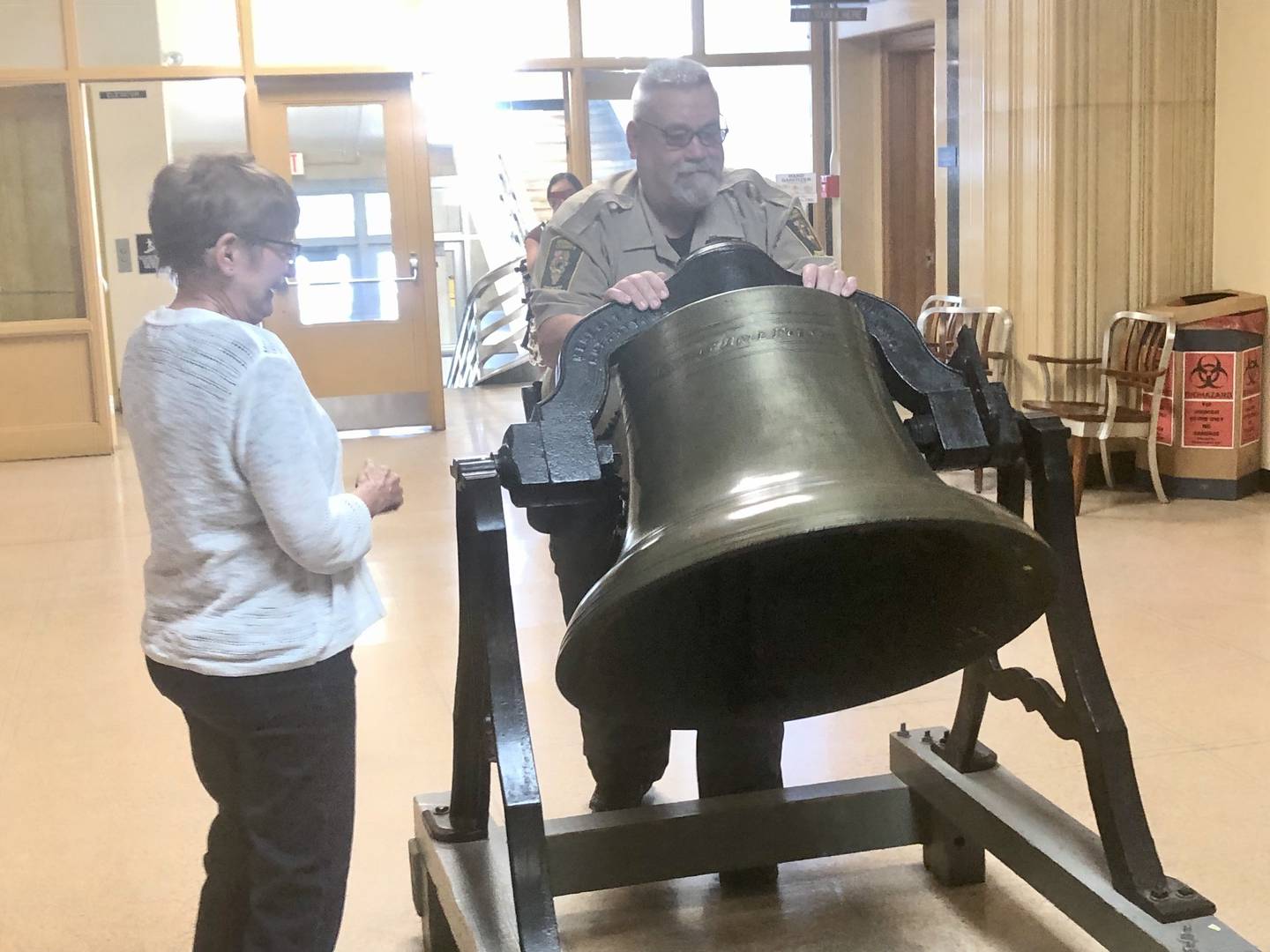 Sheriff's Deputy Cris Spiegel rings the courthouse bell in honor of Deb Landrus (left), who is retiring after 45 years working in the Bureau County Clerk's office. She is the longest tenured employer in courthouse history.