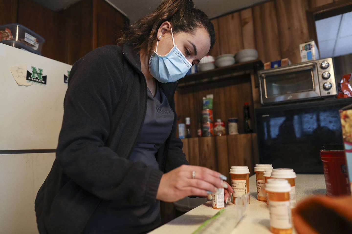 Marlene Lara prepares the weeks medication for one of the Will-Grundy Medical Clinic's clients on Friday, Feb. 12, 2021, in Joliet, Ill.