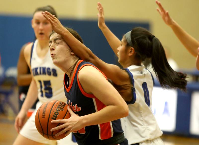 Naperville North’s Abby Homan is blocked by Geneva’s Rilee Hasegawa (0) during a game at Geneva on Tuesday, Nov. 29, 2022.
