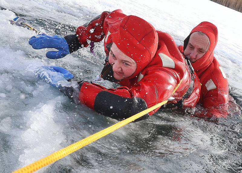 Utica firefighters Britain Siegmann and James Didricksen conduct an ice-rescue training drill on a private pond on Sunday, Feb. 1, 2026 south of Utica.