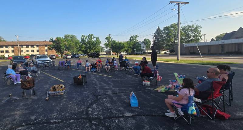Members of the Plano Methodist Church gather round campfire.